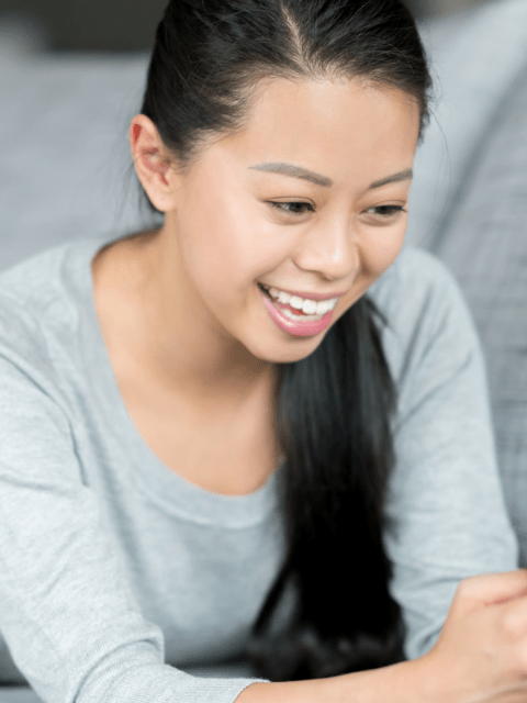 Filipino Woman at Home Using a Dating App on Her Cellphone