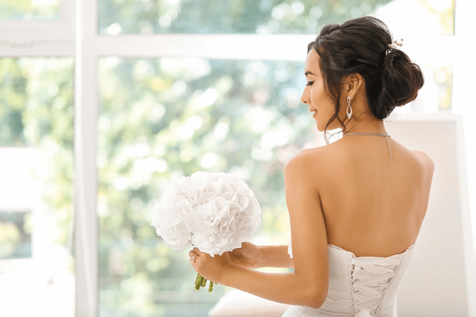 Back View of a Filipina Bride Looking at Her Bouquet of White Roses