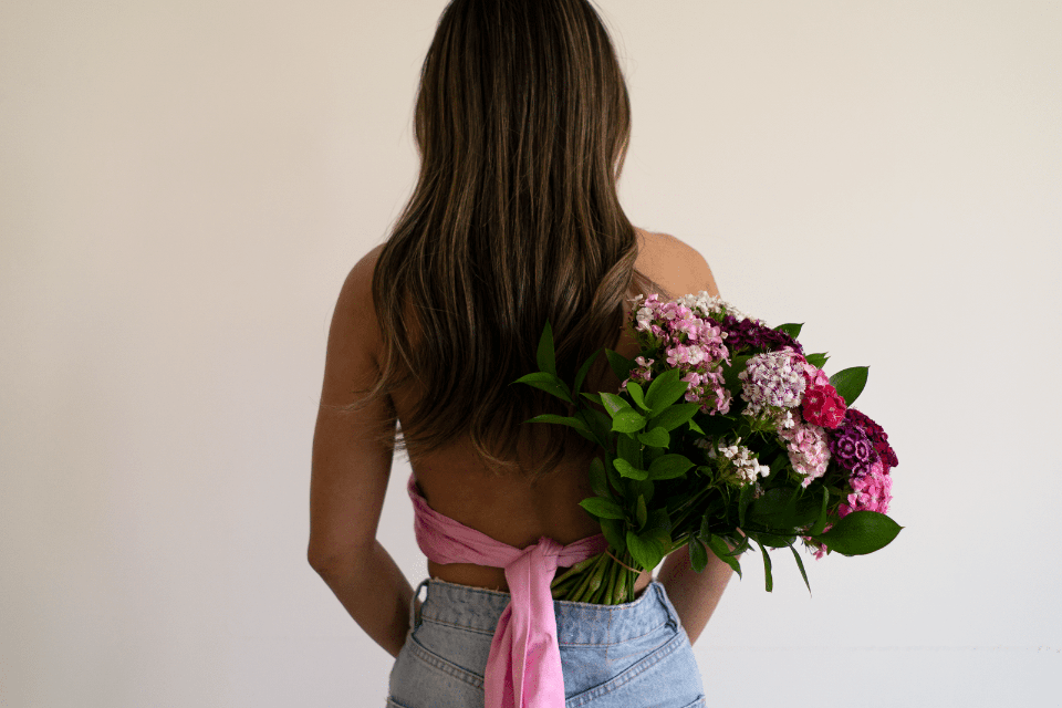 Back View of Filipina Woman with a Bunch of Flowers - Common Misconceptions about Dating Filipino Women - Blossoms Dating Blog