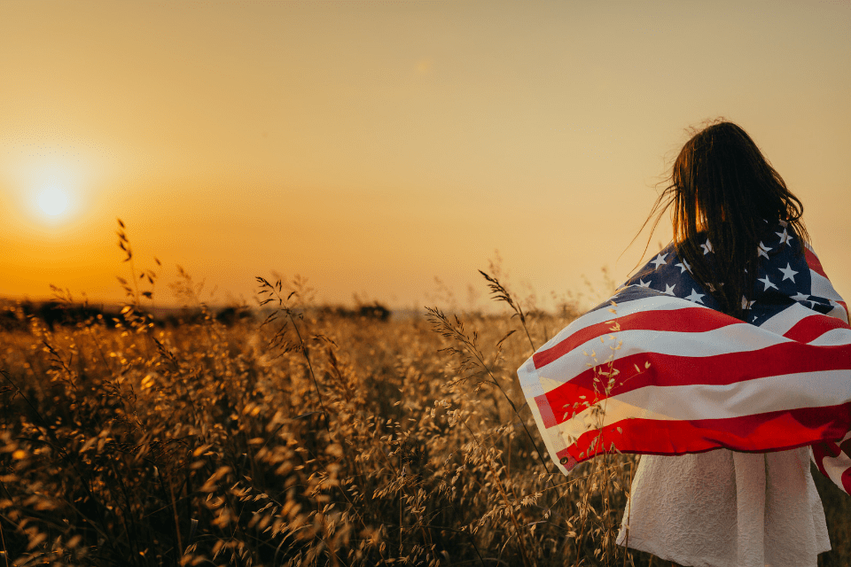 Filipino Woman with USA Flag in the Field - How Much Is a Fiancée Visa for a Filipina - Blossoms Dating Blog