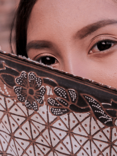 Filipina Hiding Behind a Batik Scarf While Lying