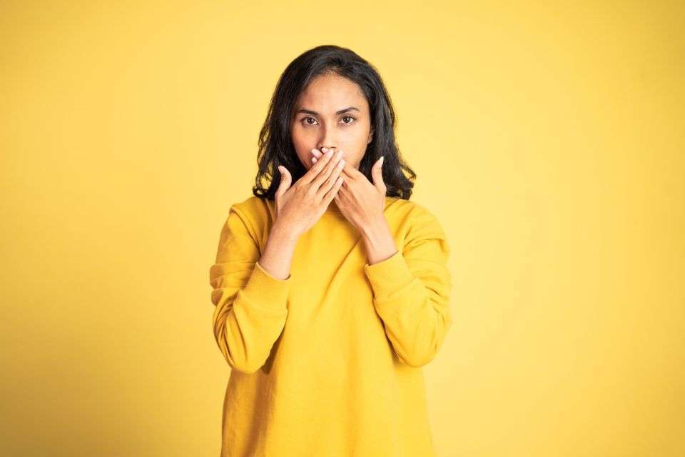 Filipino Woman Covering Her Mouth - The Pros and Cons of Dating a Filipino Woman - Blossoms Dating Blog