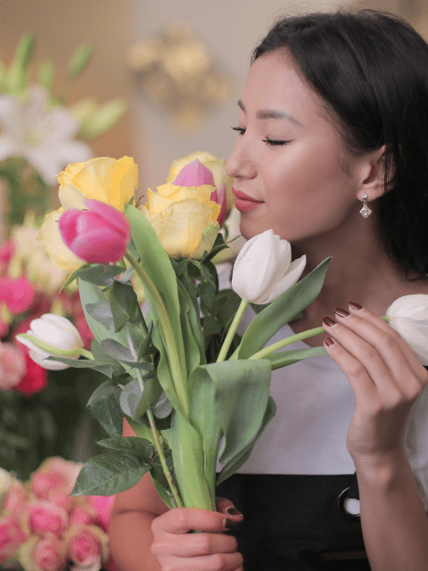 Filipino Woman in White Shirt Holding Yellow, White and Pink Tulips