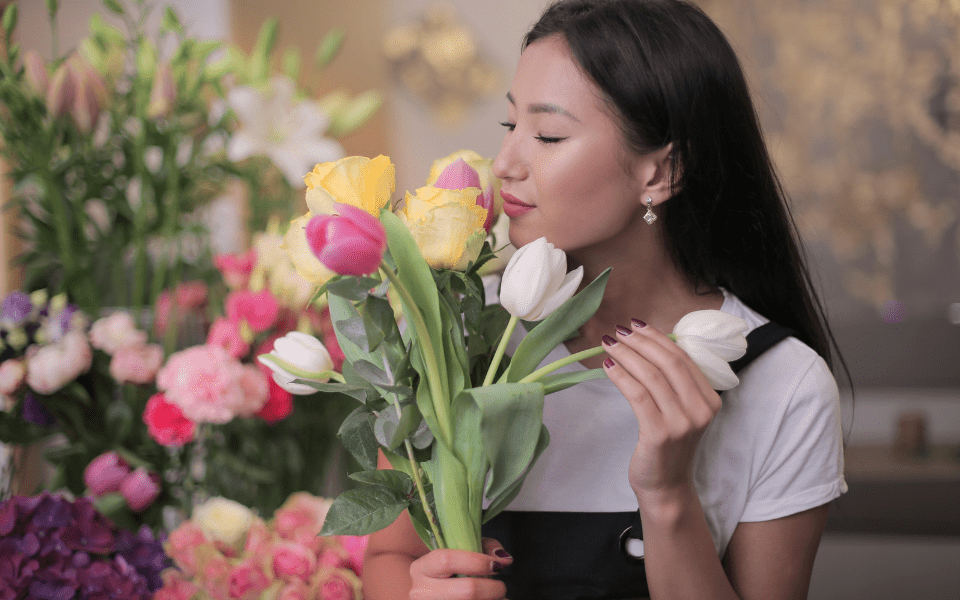 Filipino Woman in White Shirt Holding Yellow, White and Pink Tulips