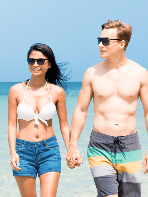 Interracial Tourist Couple Walking on a Philippine Beach in Summer