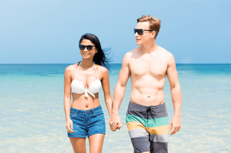 Interracial Tourist Couple Walking on a Philippine Beach in Summer