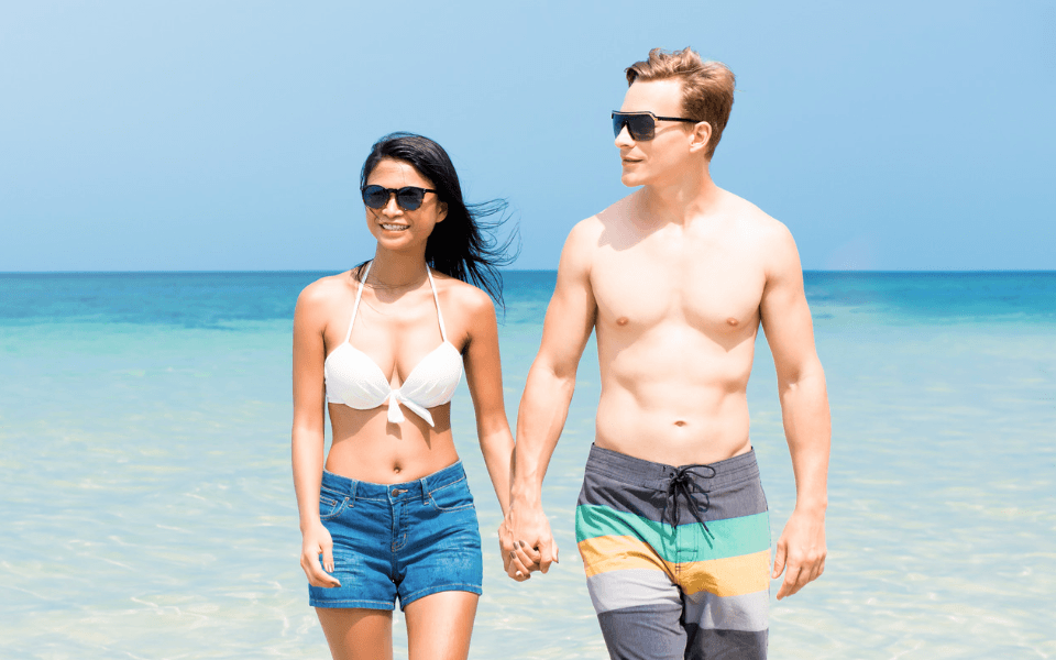 Interracial Tourist Couple Walking on a Philippine Beach in Summer