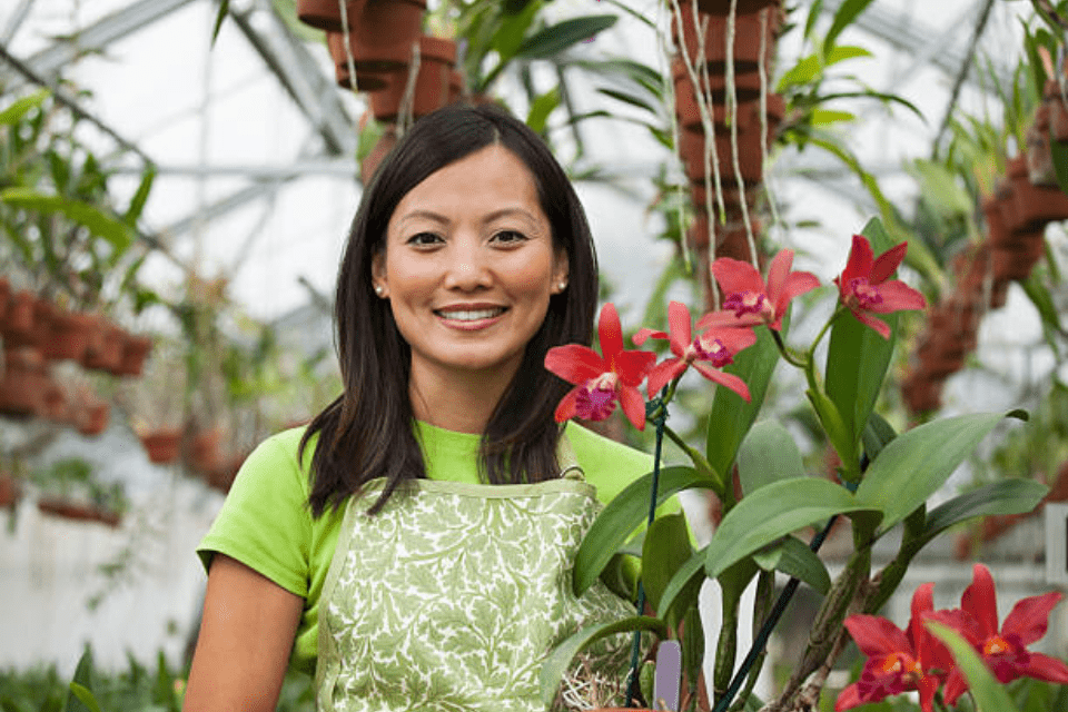 Smiling Filipino Woman Holding Orchids - The Do's and Don'ts of Dating a Filipino Woman - Blossoms Dating Blog
