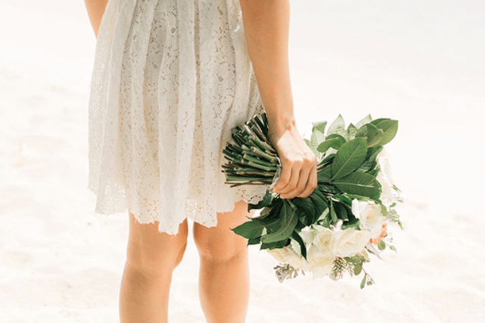 Traditional Filipina Woman at the Beach Holding a Bouquet of Flowers