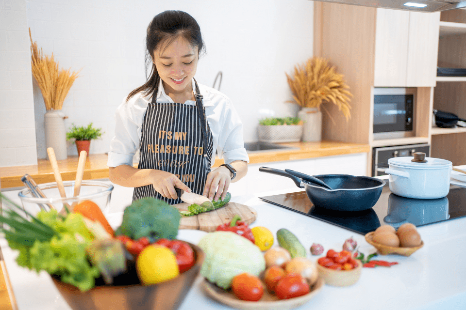 Young Filipina Cooking in a Modern Kitchen