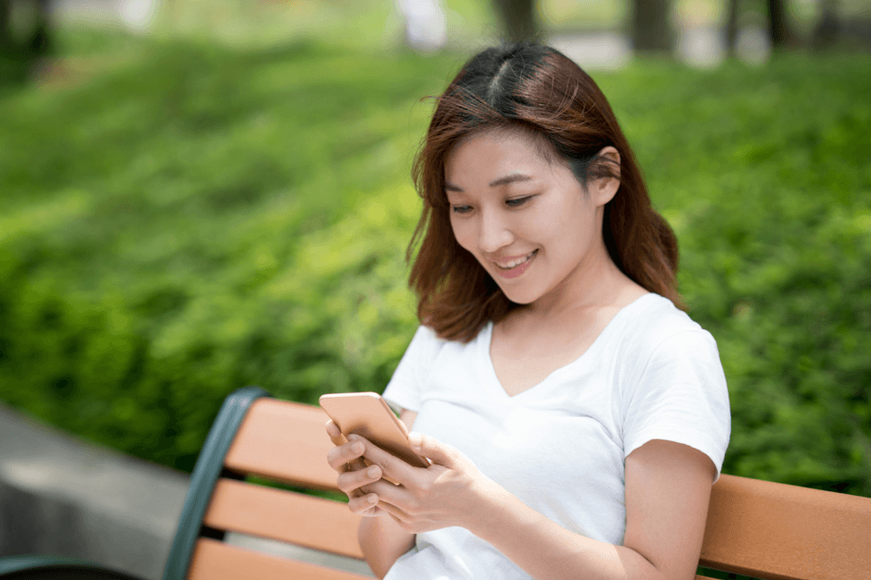 Filipina Texting Her Online Date on Her Mobile Phone