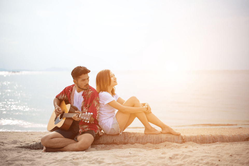 Handsome Hispanic Man Serenading His Cute Filipino Girlfriend t the Beach - Romantic Gestures in Filipino Dating - How to Sweep Your Partner Off Their Feet