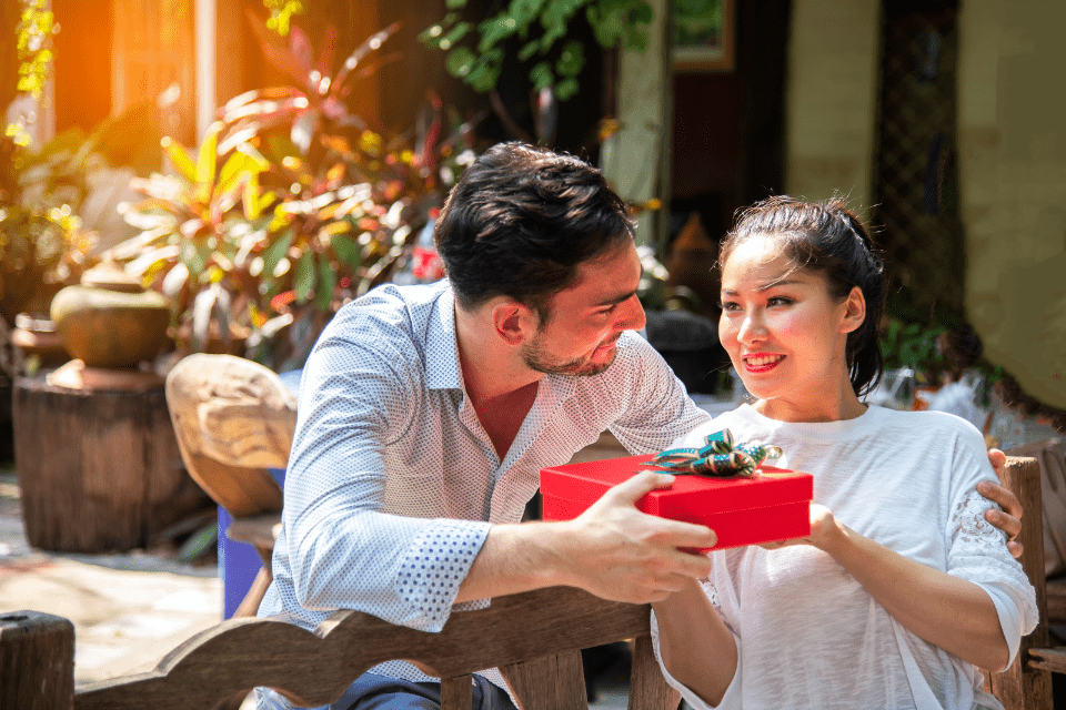 Young American Man Giving His Filipina Partner a Gift During Courtship 