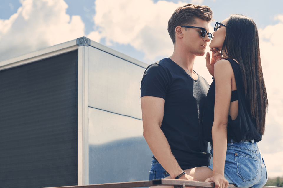 Young Interracial Couple About to Kiss on the Railings of the Roof - Navigating the Challenges of Filipino-Foreigner Relationships - Blossoms Dating Blog