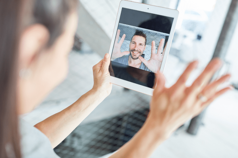 Long-Distance Couple Talking Via Video Chat - Simple Guide to Navigating Long-Distance Online Dating - Blossoms Dating Blog