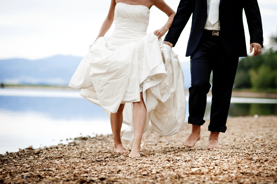 Bride and Groom Walking Barefeet in Sand
