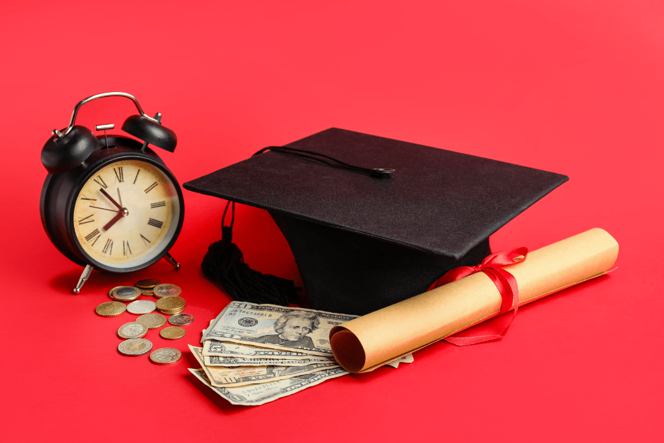 Graduation Cap, Money, Alarm Clock and Diploma Against a Red Background - Tution Fees Concept Used to Request for Money In Filipina Dating Scams