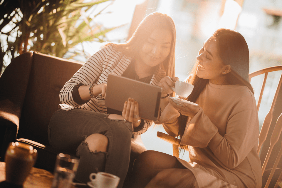 Hip Filipino Single Women Using a Tablet in a Cafe