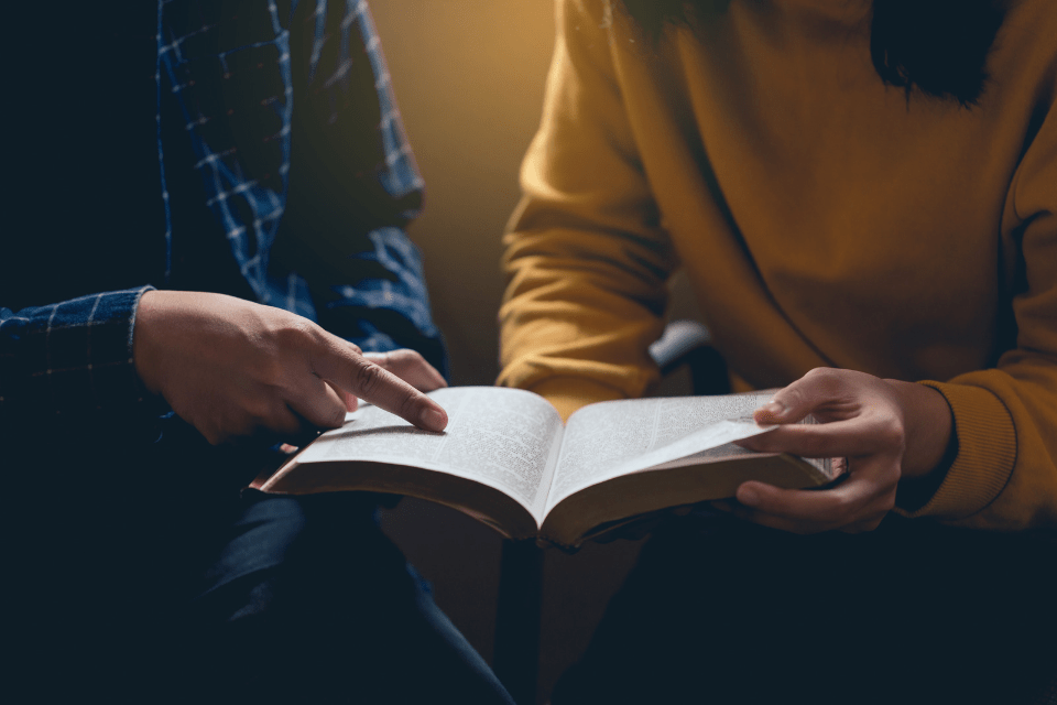 Man Reading the Holy Bible and Sharing the Gospel With a Christian Filipino Woman