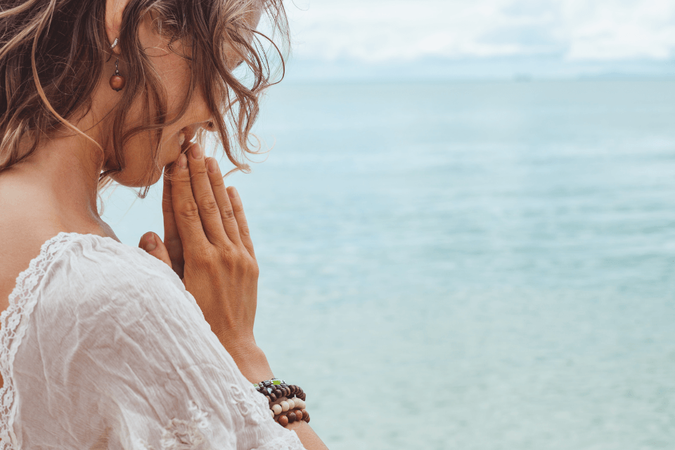 Beautiful Christian Filipina praying on the beach.