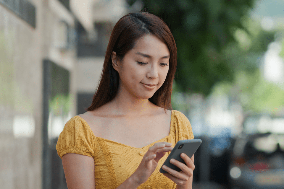 Christian Pinay using her mobile phone to communicate with her foreign date online.