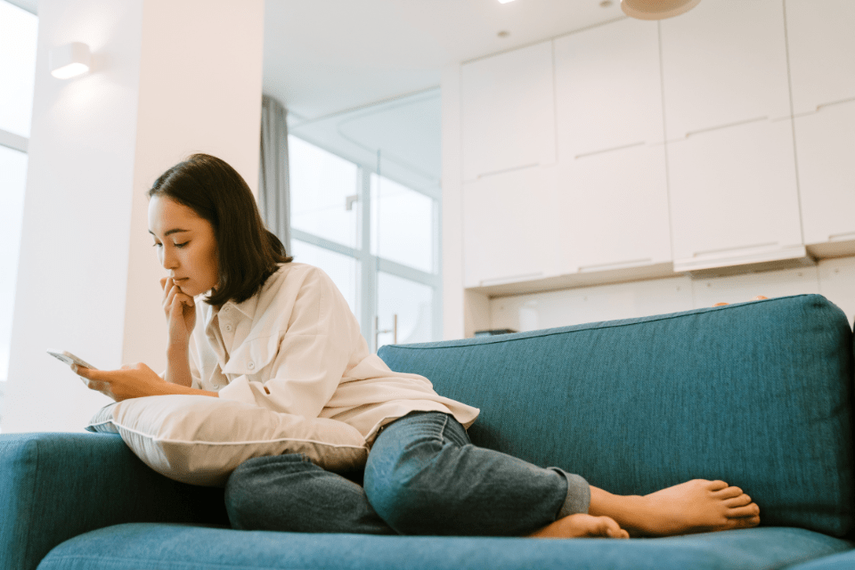 Cute Christian woman using her smartphone to communicate with her online date.