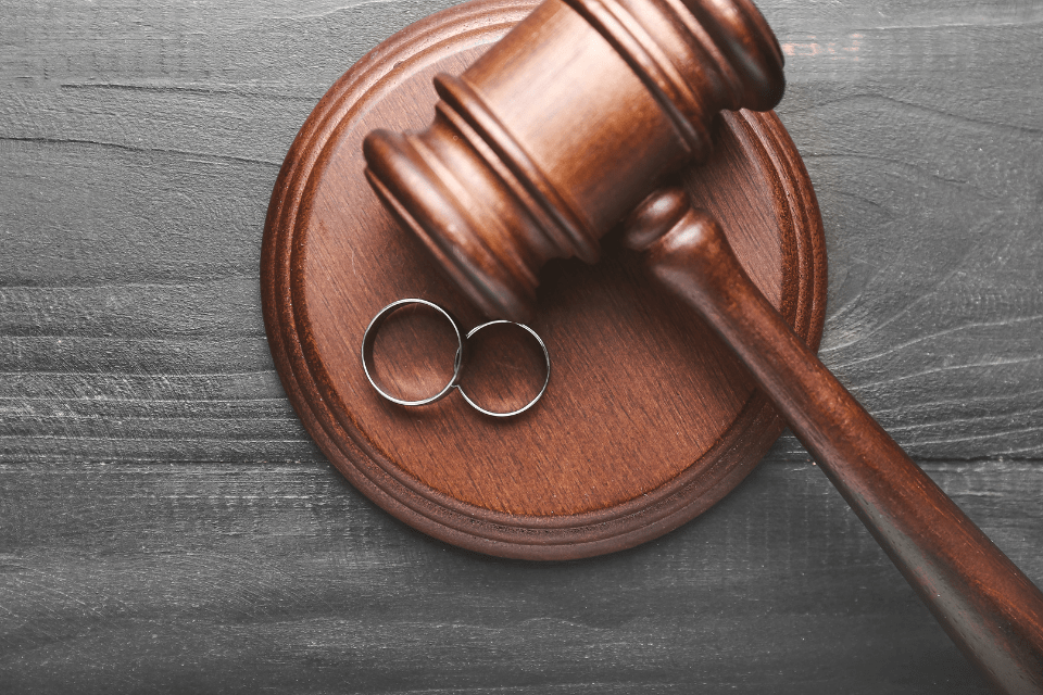 Judge's gavel and rings on wooden background as concept of annulment.