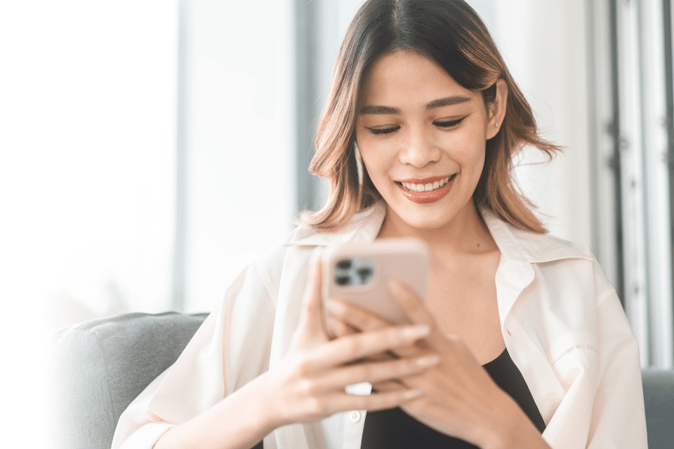 Young Christian Filipina using her smartphone to date online.