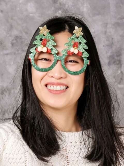 A Filipina woman wearing festive Christmas eyewear and smiling brightly.