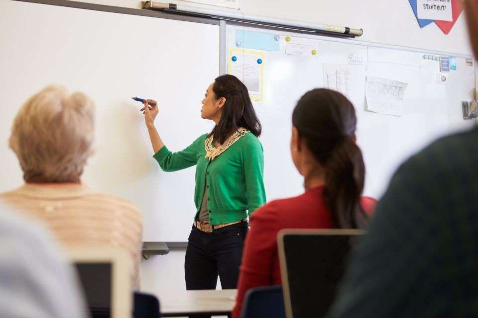 A Filipina Writing on a Whiteboard During an Adult Class