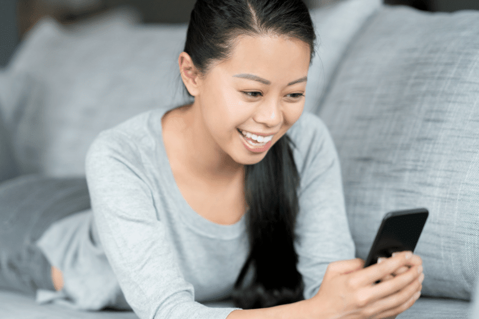 Filipino Woman at Home Using a Dating App on Her Cellphone